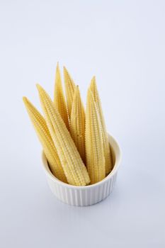 Baby corn on a white background, close-up