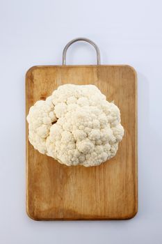 Cauliflower isolated on top of cutting board