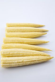 Baby corn on a white background, close-up