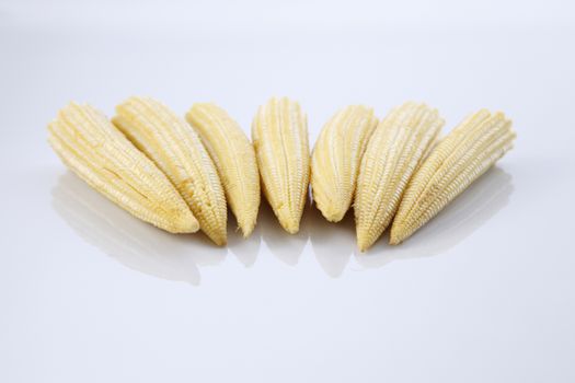 Baby corn on a white background, close-up