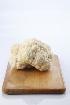 Cauliflower isolated on top of cutting board