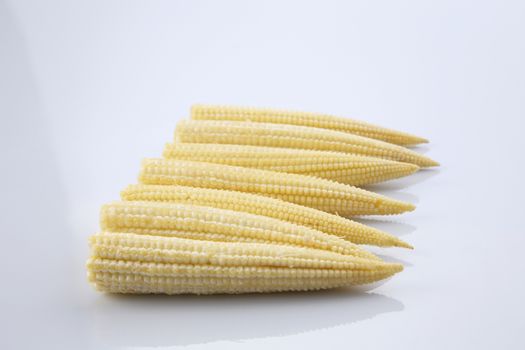 Baby corn on a white background, close-up