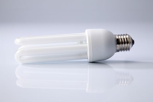 Energy saving fluorescent light bulb on white background