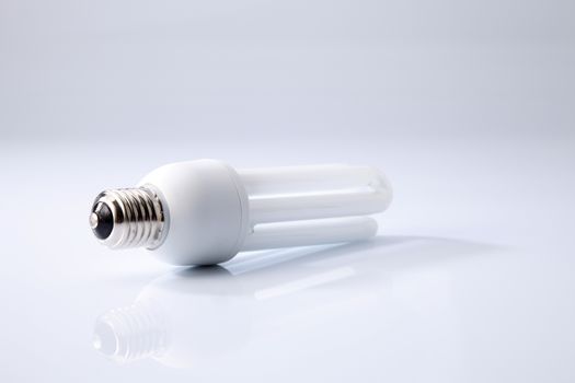 Energy saving fluorescent light bulb on white background