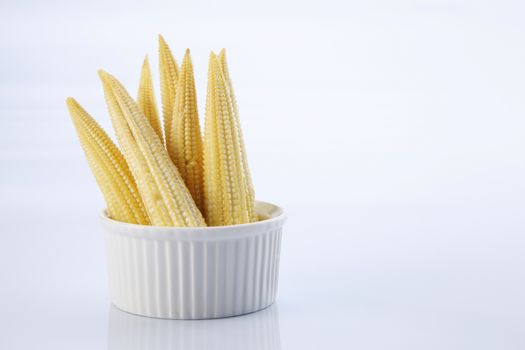 Baby corn on a white background, close-up