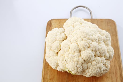 Cauliflower isolated on top of cutting board