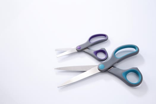 two pair of scissors which one big and small on the white background