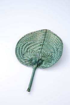 Green color native fan made from palm leaves on white background