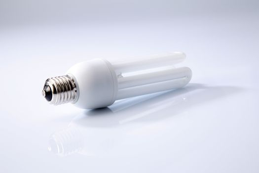 Energy saving fluorescent light bulb on white background