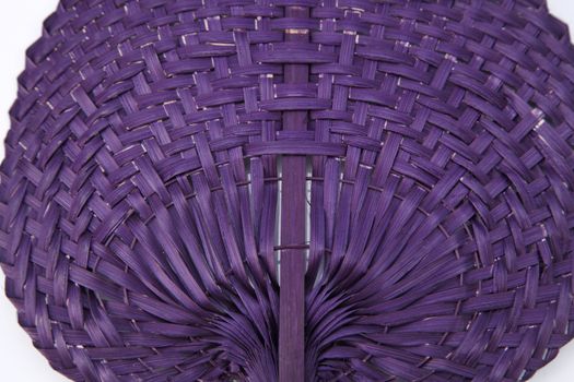 Purple color native fan made from palm leaves on white background