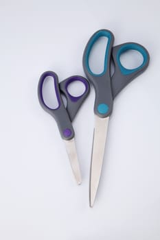 two pair of scissors which one big and small on the white background