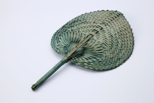 Green color native fan made from palm leaves on white background