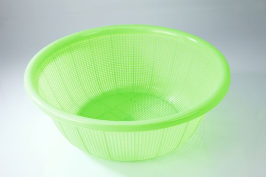 green plastic basket on a white background
