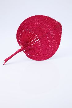 Pink color native fan made from palm leaves on white background