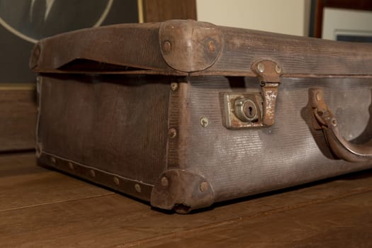 A rusty lock on an old brown leather suitcase