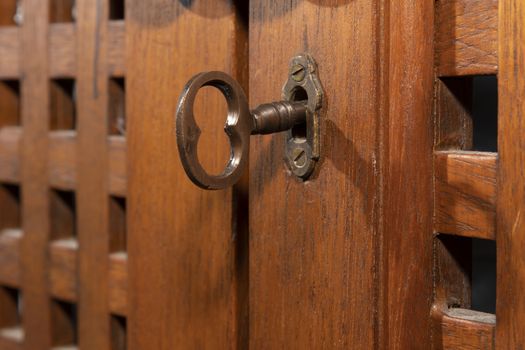 An antique key in an old wooden cupboard