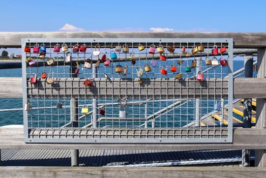 Many Love locks hanging at a pier at a baltic sea beach