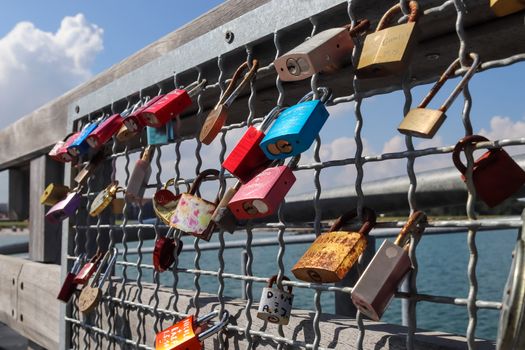 Many Love locks hanging at a pier at a baltic sea beach