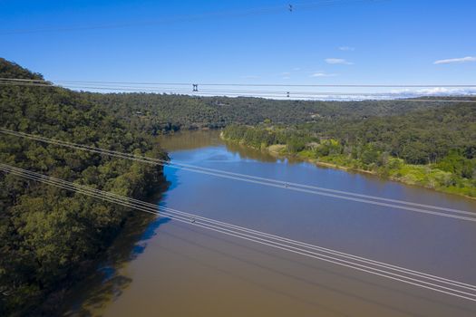 An electricity transmission tower and cables across a river in regional New South Wales in Australia
