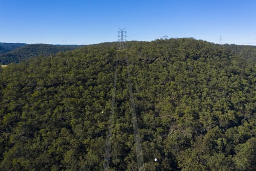 An electricity transmission tower and cables across a river in regional New South Wales in Australia