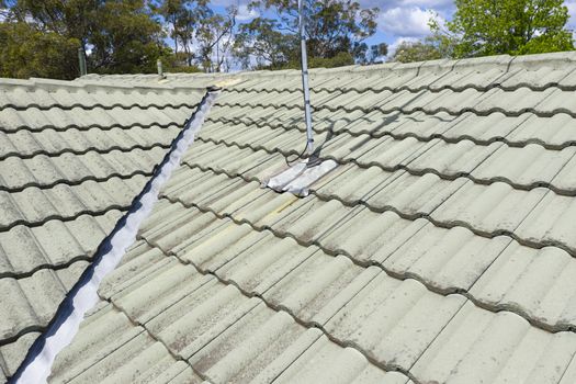 Close up of green tiles on a  roof in the sunshine