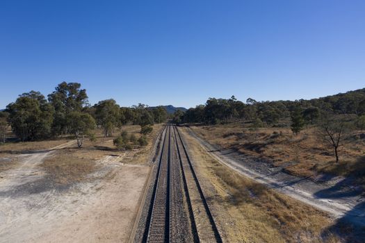 Railway tracks heading into the Australian outback.