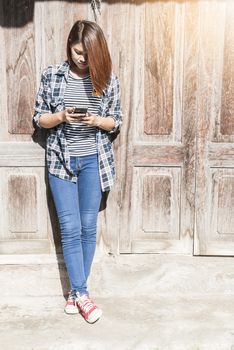 woman standing using her phone with wooden background