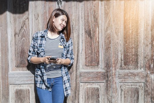 young woman happy with her phone and wooden background