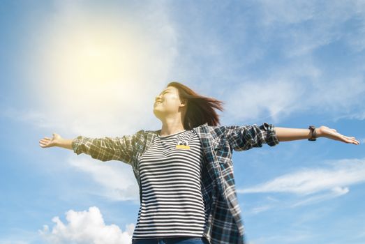 happy young woman dreams to fly with blue sky background