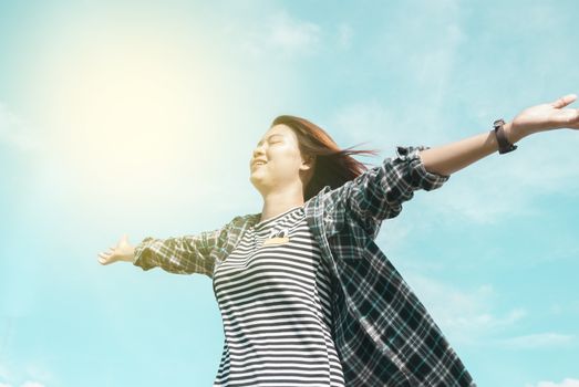 happy young woman dreams to fly with blue sky background