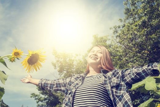 smiling youg woman with sunflower and blue sky background