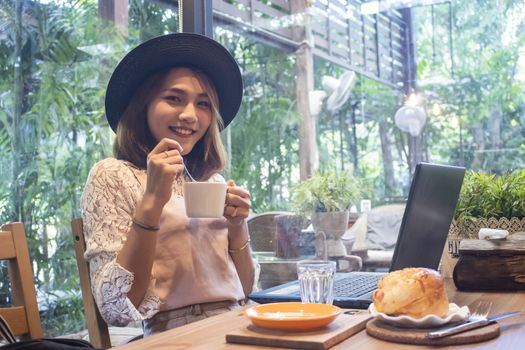 Young asian woman drinking coffee in a cafe