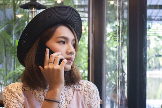 Young asian woman sitting at cafe' and talk to the phone