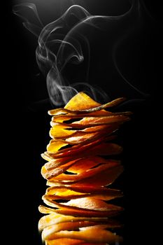hot mexican nachos tortilla chips stack with smoke, black background