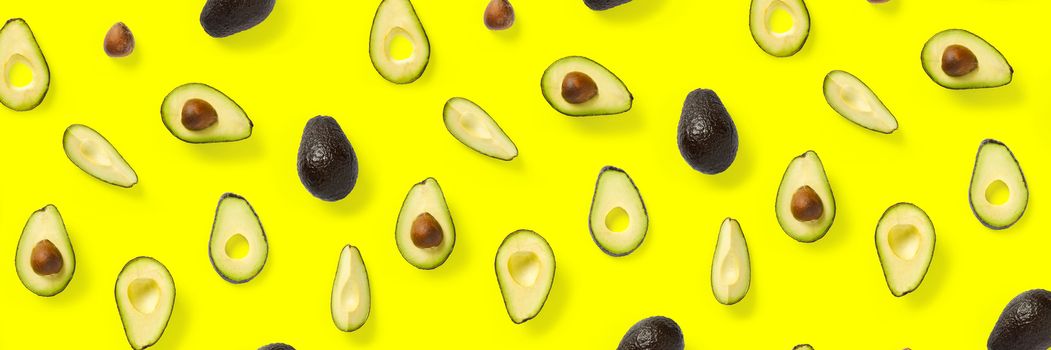 Avocado banner. Background made from isolated Avocado pieces on yellow background. Flat lay of fresh ripe avocados and avacado pieces