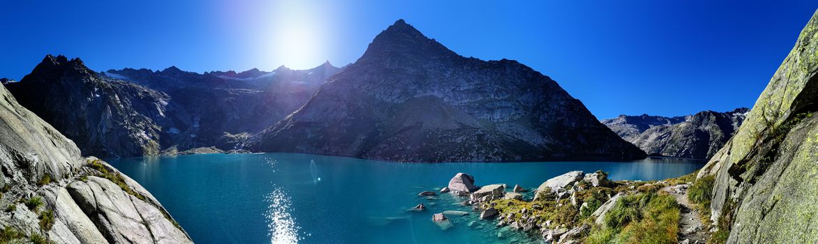 Gelmersee. Dam in the Swiss alps for Hydro power. Clear Blue lake with clear sky.