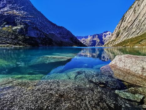 Gelmersee. Dam in the Swiss alps for Hydro power. Clear Blue lake with clear sky.