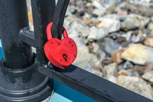 A padlock attached to the railing of the bridge as a symbol of a strong family marriage