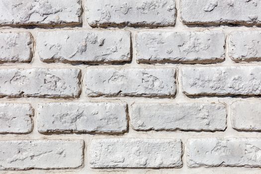 Background and texture of an old brick wall painted white, closeup.