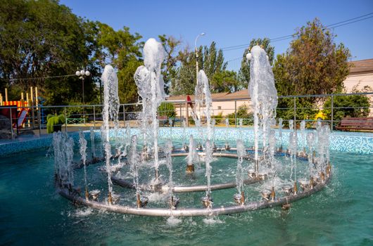 Fountain in the children's Park.Several jets spray up.Sunny day