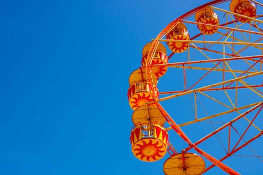 Yellow Ferris Wheel against a blue sky. Space for your text