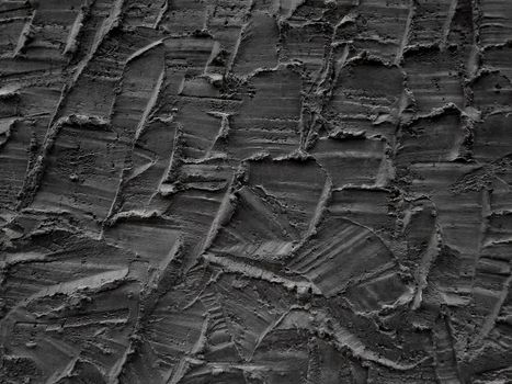 Decorative relief adhesive plaster. Black stucco wall. The black background of the wall.