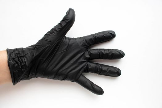 Hand in a black surgical medical glove, isolated on a white background. Production of rubber protective gloves.Hygiene and sanitary standards