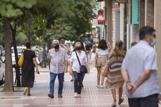 Zaragoza, Spain - August 18, 2020: People walking with face masks, due to the coronavirus pandemic, in the central area of Zaragoza.