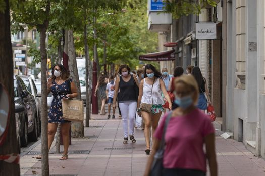 Zaragoza, Spain - August 18, 2020: People walking with face masks, due to the coronavirus pandemic, in the central area of Zaragoza.