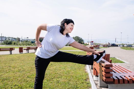 Sport and fitness. Senior sport. Active seniors. Smiling senior woman warming up stretching outdoors in the park