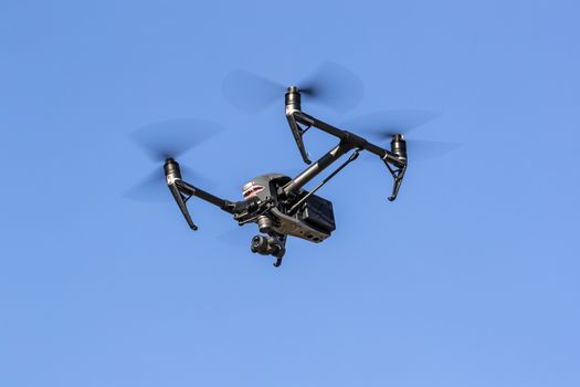 A group of drones fly through the air against a blue sky