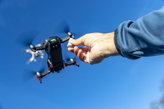 A group of drones fly through the air against a blue sky