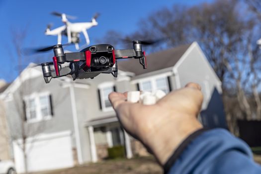 A group of drones fly through the air against a blue sky