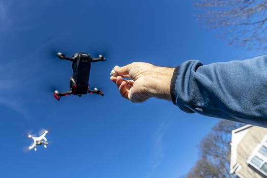 A group of drones fly through the air against a blue sky